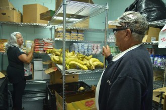Clinic Coordinator Gracie Medina helps fill a food prescription with Manuel Gonzalez, who has Type 2 diabetes. She explains in Spanish how best to cook quinoa and asks if he’d like to try some. (Christina Ren/Peninsula Press)