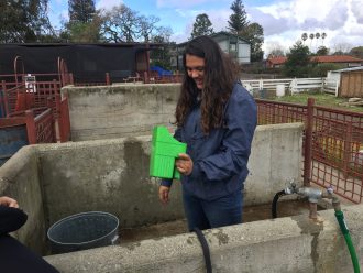 A young woman holds a feeding container.