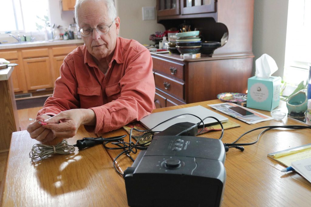Tom Devine attaches a backup battery to his CPAP device