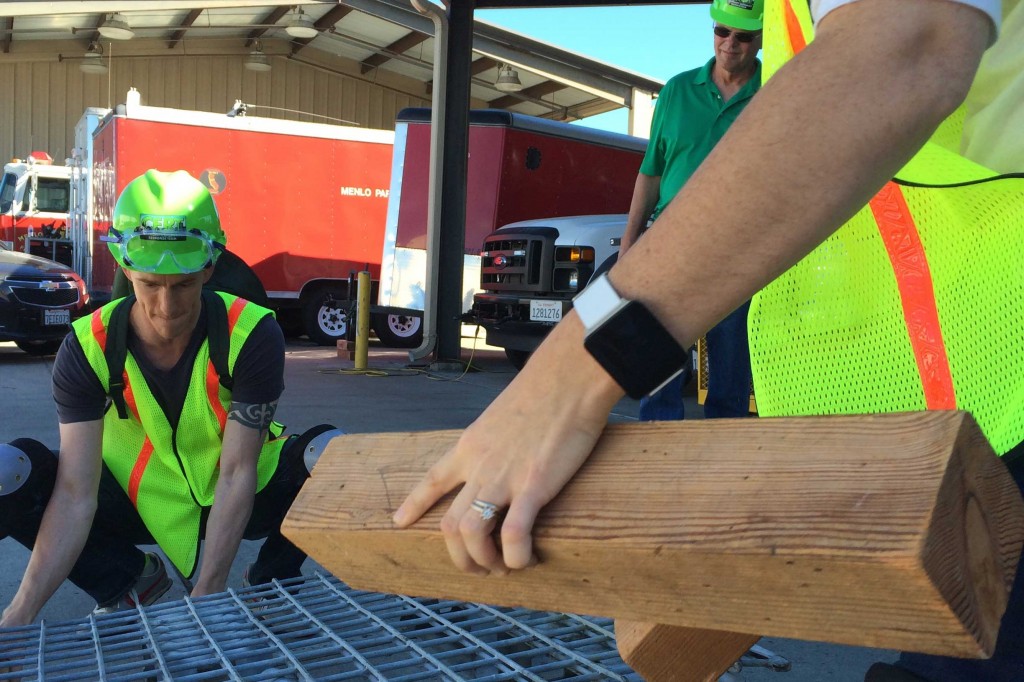 Matt Clemens, a patent lawyer, and other trainees use wooden blocks to lift a heavy metal crate off a dummy in a victim rescue simulation on Oct. 18, 2014. Clemens said the three-day training helped him put together an emergency preparedness plan for he and his family. (Farida Jhabvala Romero/Peninsula Press)