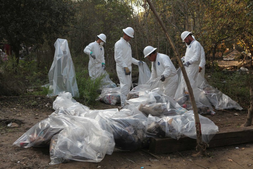 Crews clean up trash at the previous homeless encampment site on Dec. 8, 2014, in San Jose. The 68-acre land bordering Coyote Creek, where about 300 people live in tents and tree houses, used to be one of the biggest homeless encampments in the country. (Yuqing Pan/Peninsula Press)
