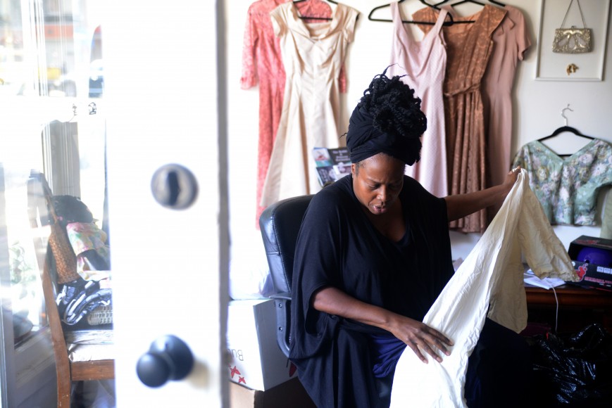 Evans sorts through clothes at her store in downtown Oakland.  (Travis Shafer/Peninsula Press)