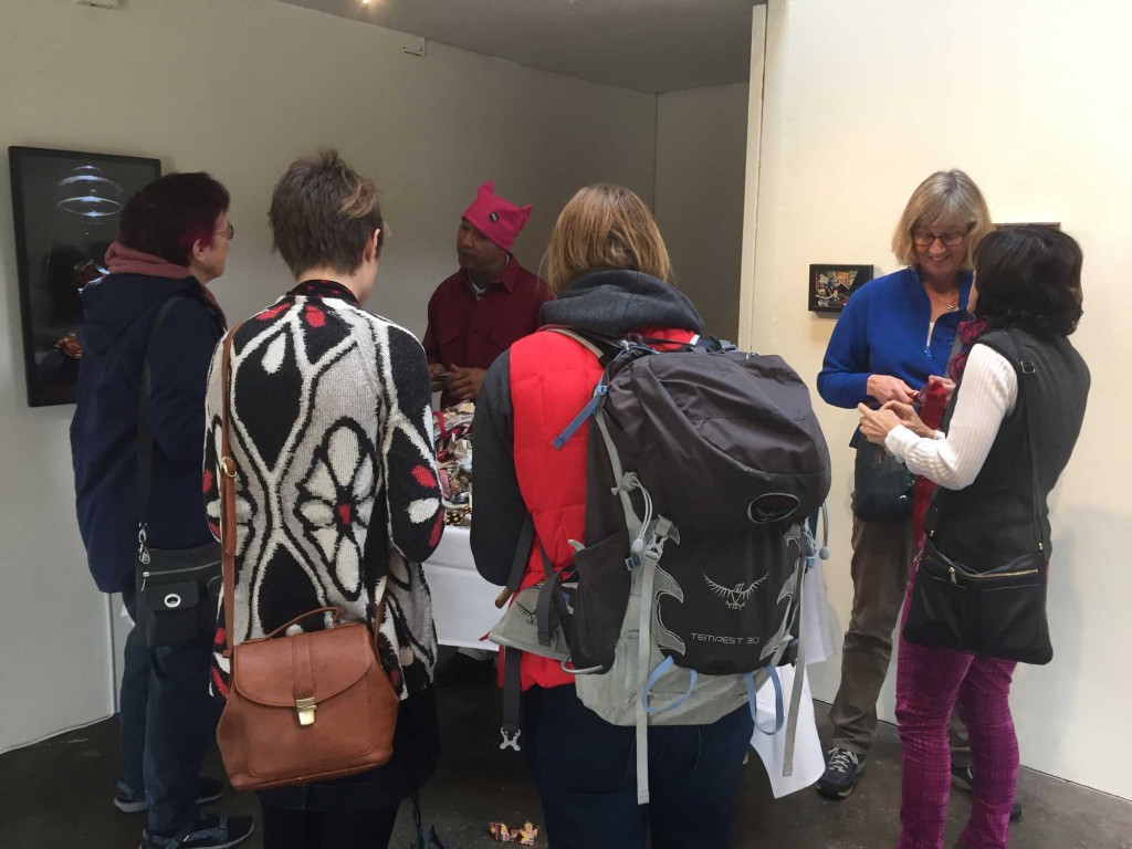 Ramekon O'Arwisters guides visitors to participate in a social art practice through crocheting recycled fabric scraps at the Recology Open Studios. (Dylan Anslow/Peninsula Press)