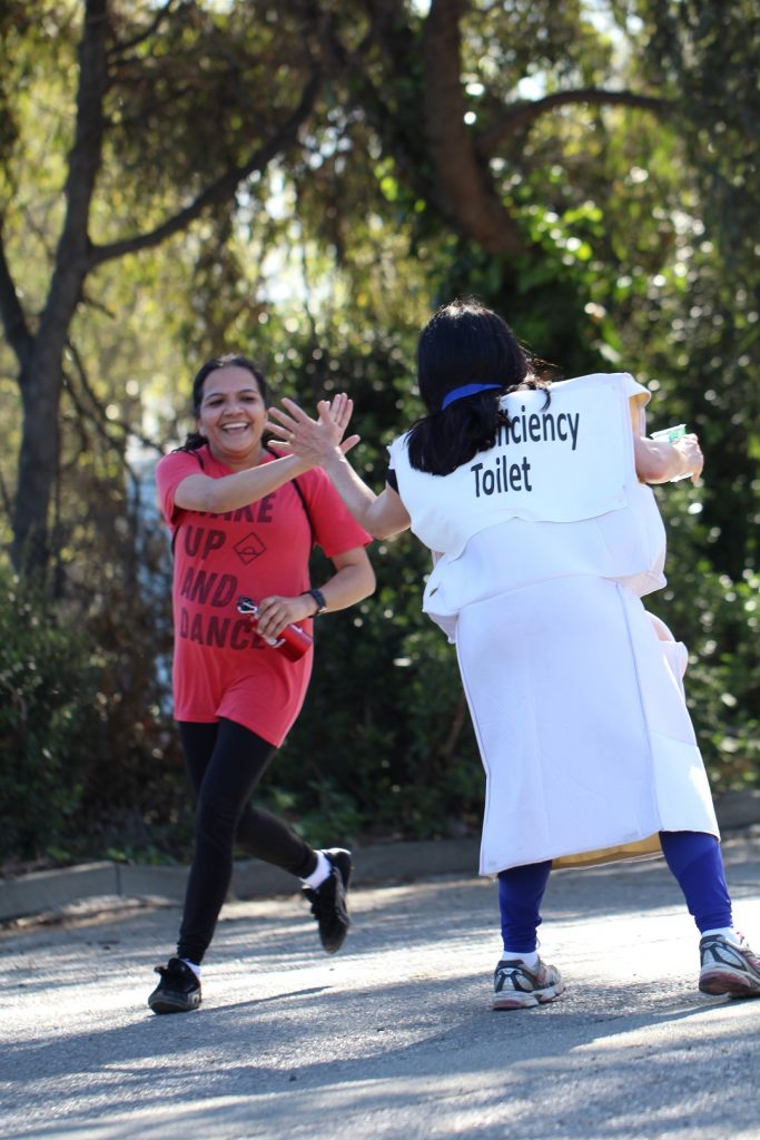 Ora Chaiken high fives 5k finishers.