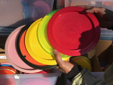 A hand holds up several brightly colored discs.