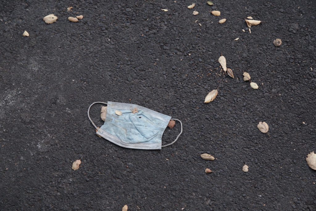 A mask is left on the ground outside of Arrillaga dining hall. (Noah Cortez, Peninsula Press)