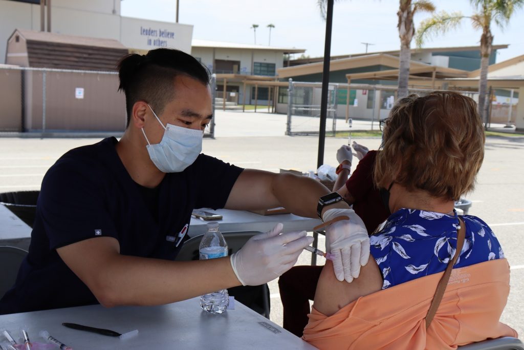 A woman receives a vaccine shot.
