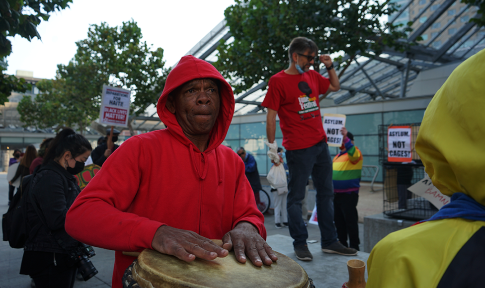 Takuma King, Director of the Bay Area Youth Arts Program, beats a ngoma drum during a protest in San Francisco, Friday, Sept. 24, 2021. The protest gathered about 50 individuals to rally against the treatment of Haitian refugees at the Texas Border. (Elissa Miolene/Peninsula Press) 