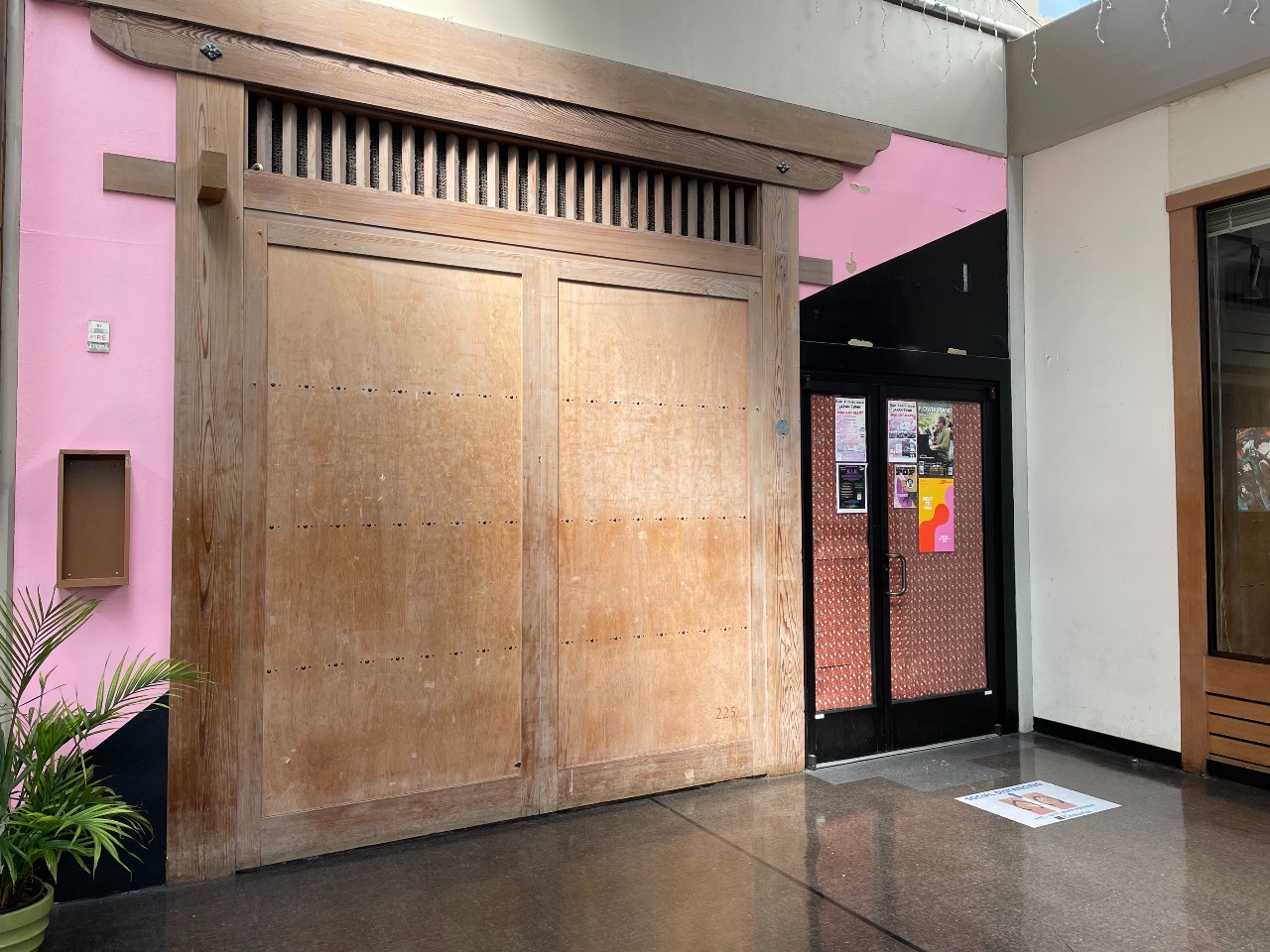 A store is boarded up with a large wooden door.