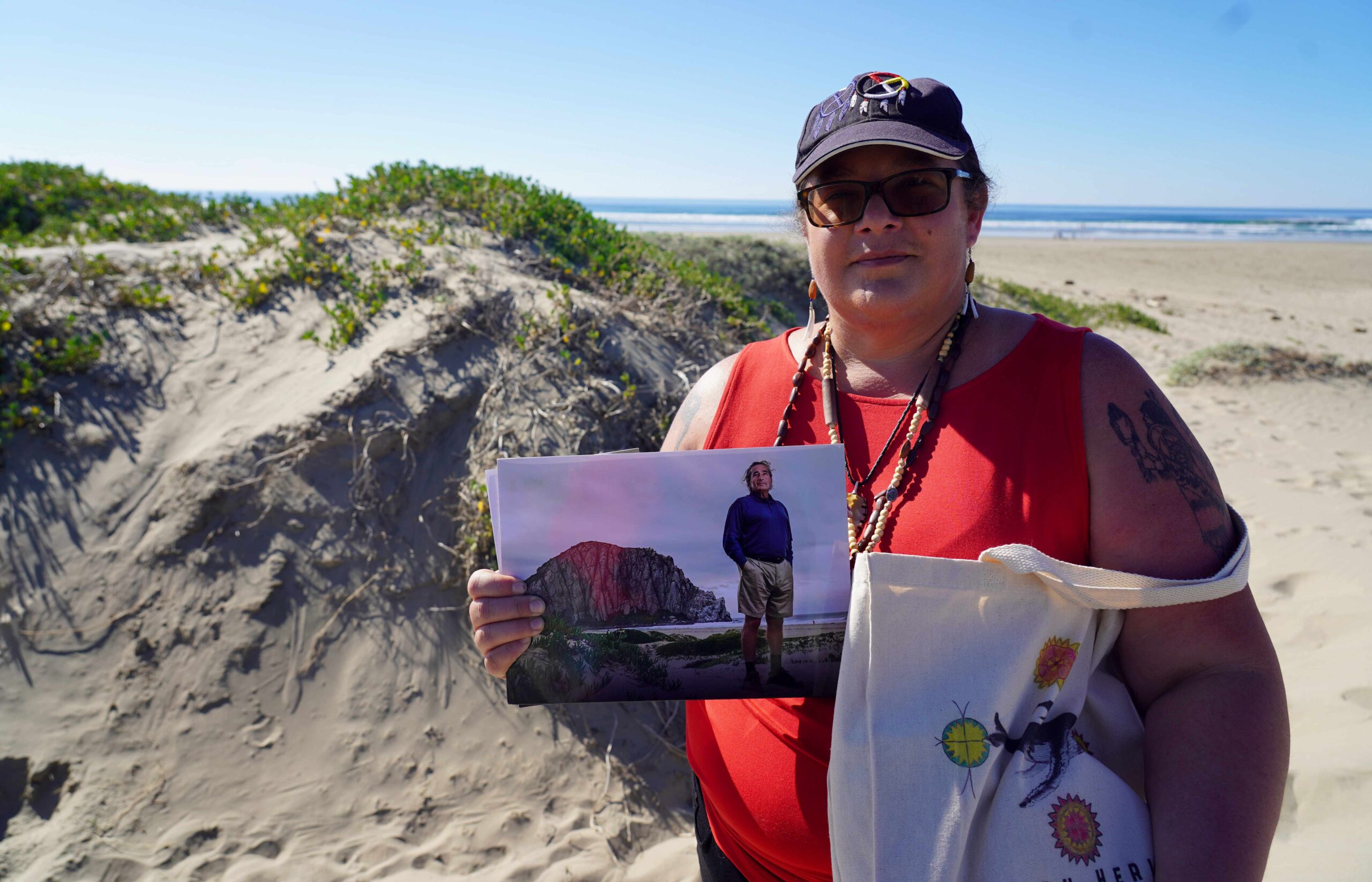 A woman with a baseball hat holds up a picture