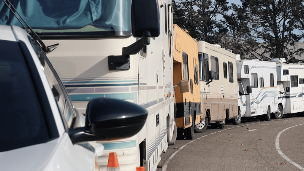 A photo of a line of parked RVs on a street.