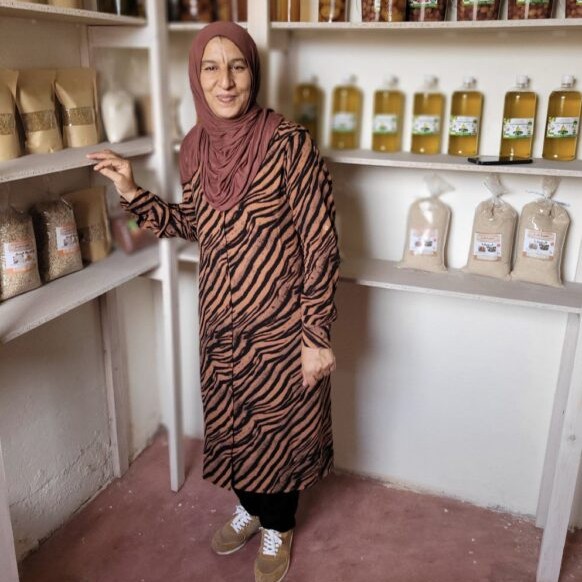 givedirectly_edited A woman stands in front of what looks like store shelves.