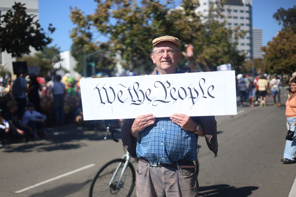 IMG_0635_edited A man holds up a sign during the Oakland No Kings Day Protest.