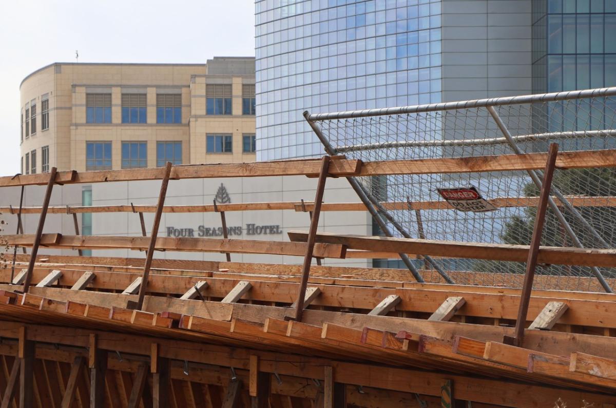 Pedestrian bridge with Four Seasons Hotel in the background.